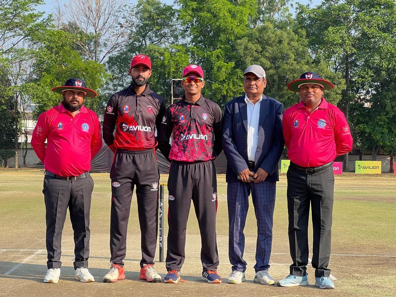 Team captains and umpires posing before an Avilion fixture