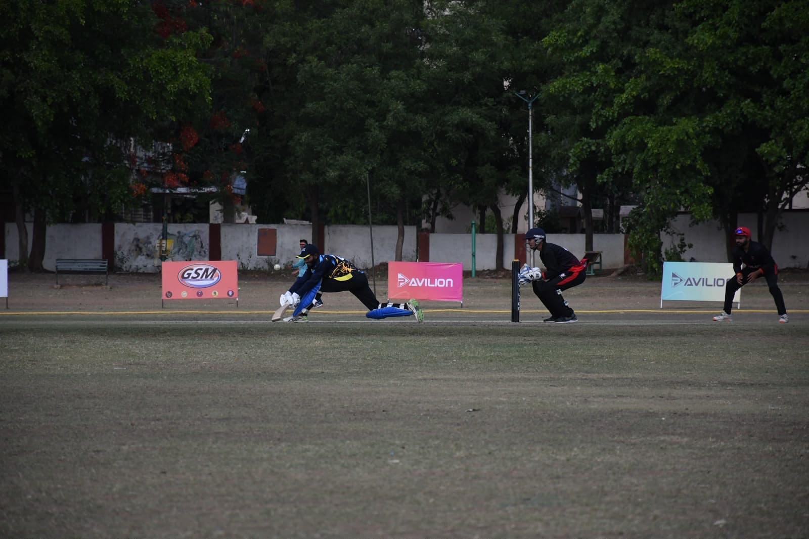Wicketkeeper diving for the ball at a GSM-managed match